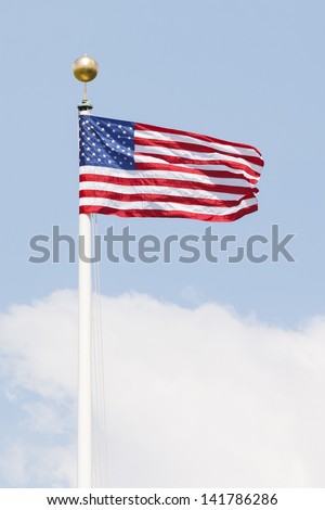 American flag on a flag pole waving against the sky