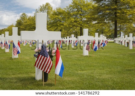 Grave markers at the American War Cemetery of Margraten in the Netherlands, decorated with flags for Memorial Day.