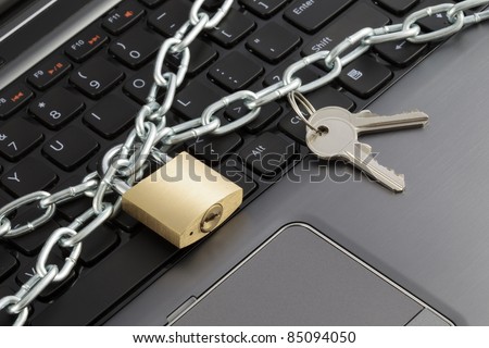 Closeup of a keyboard with chains, a lock and keys, representing the concept of computer security.