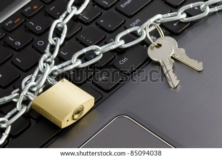 Closeup of a keyboard with chains, a lock and keys, representing the concept of computer security.