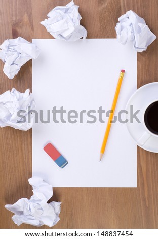Crumpled paper balls and blank sheet of paper with pencil