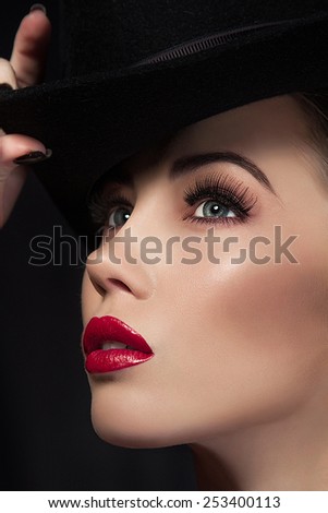 Closeup Hi-End retouch portrait of beautiful model. Modern fashion make up . Red lips and perfect soft skin. Lady in black hat