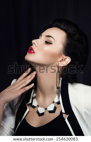 Fashion portrait of stylish brunette girl with red lips. Cool modern make up. Hi end retouch. Perfect skin. White jacket.