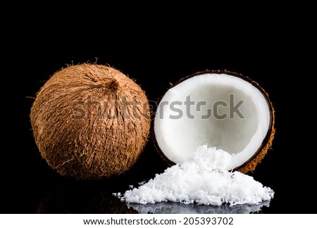 Coconuts and coconut flake on black background.