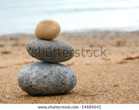 3 stones stacked up on beach