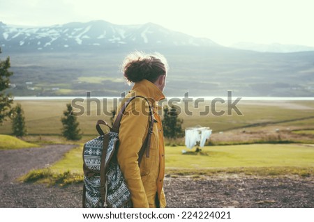 young hipster man looking at the mountains