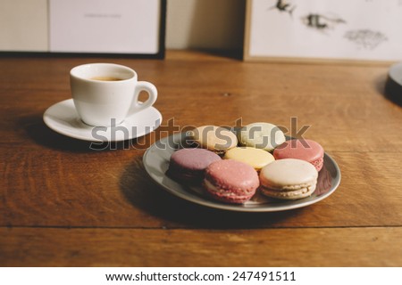 Fresh morning espresso coffee and some french macarons dessert on the wooden table background