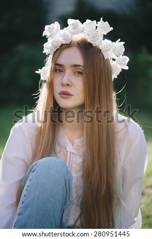 Beautiful redhead young woman in a deep thought in the summer park
