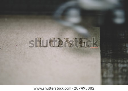 Industrial laser engraving word love on a paperboard