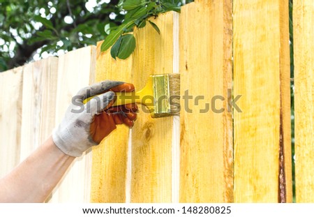 Man painting wooden furniture piece