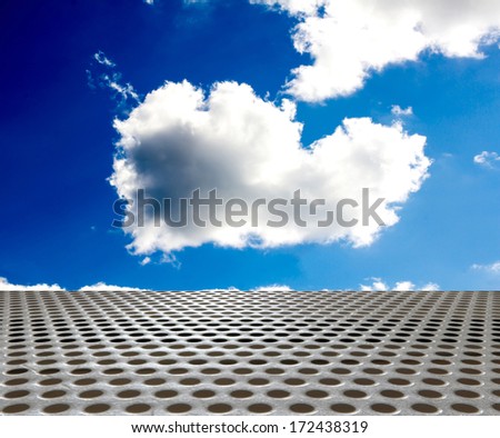 silver metal floor with round hole on the background of blue sky