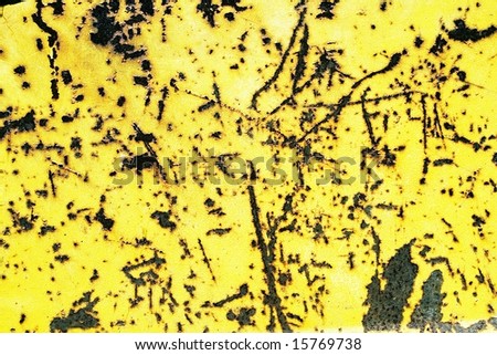 The painted metal plate by a yellow paint filled with scratches and rusts