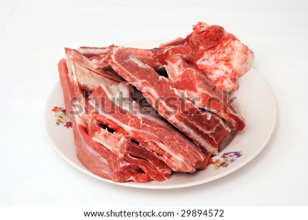 The Volume of exciting fresh damp meat of beef on plate insulated in white