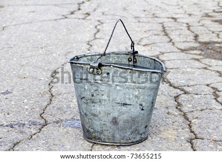 old pail with water on road