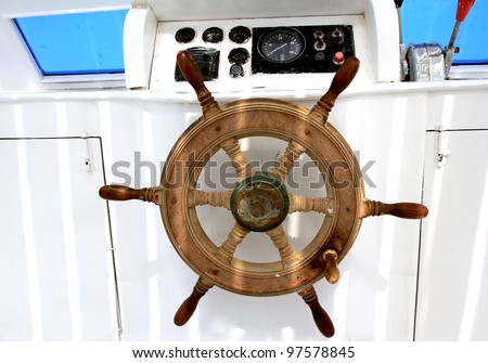 The wood steering wheel of a captain\'s bridge on the boat