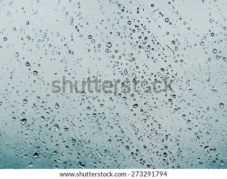 Water drops on glass against the storm sky