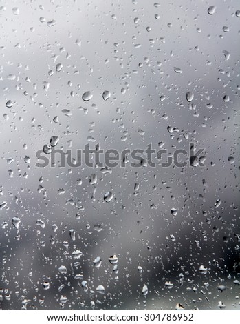 Raindrops on a window pane on the background of a stormy sky.