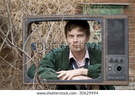 serious man in old tv box, on street