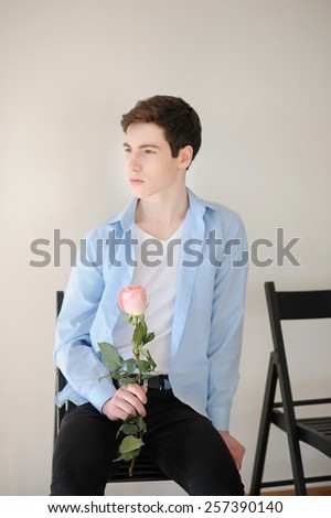 Handsome young man with single pink rose