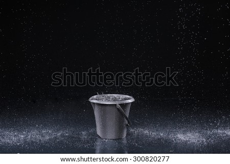 Bucket with water drops on dark background