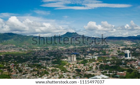 view of Tegucigalpa city in Honduras, houses and buildings in the city, mountains in the background. photo taken on a partly cloudy summer day.