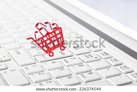 Shopping basket with gift boxes on computer keyboard  as online shopping concept