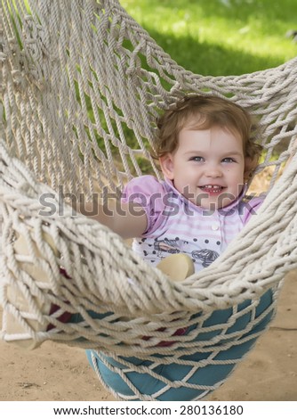 Adorable baby playing in rope hammock swing chair
