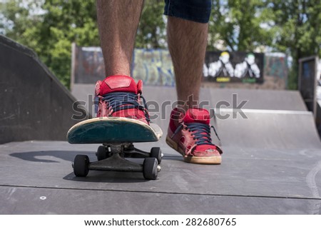 Close up of  sneakers and skateboard in the skateboard park