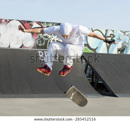 Skateboarder doing a jumping trick at skateboard park