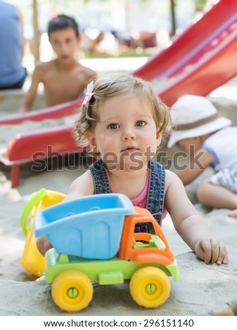 Beautiful baby playing in the sand box