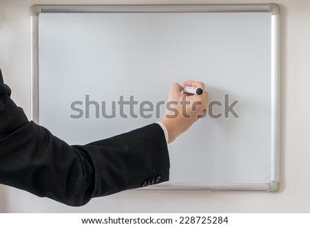Teacher writes on whiteboard with marker