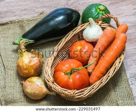 Mixture of vegetables in wicker basket on jute bag