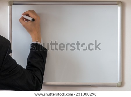 Teacher\'s hand writing on blank whiteboard