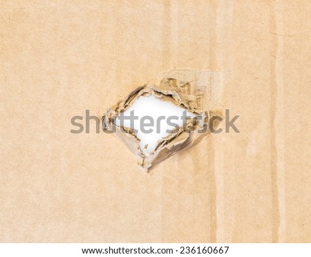 Torn hole in cardboard paper