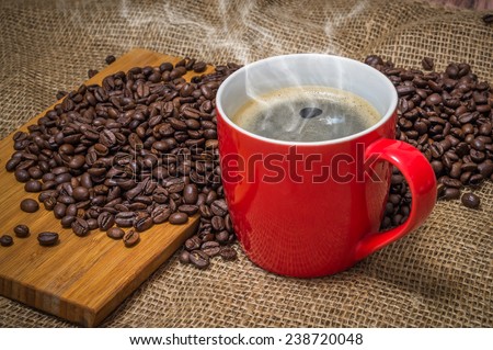 Cup of coffee and spilled coffee beans
