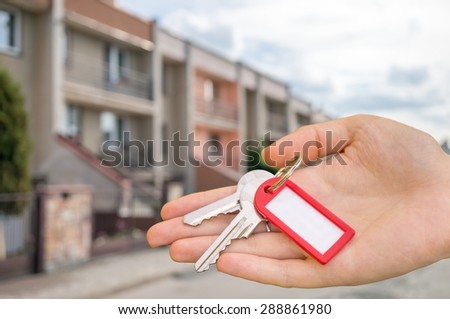 Real estate is selling house and holds keys in hand