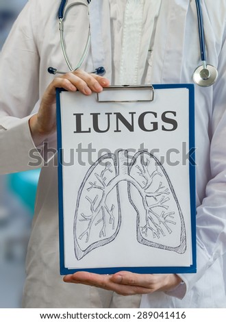 Doctor holds clipboard with lungs drawing to explain anatomy