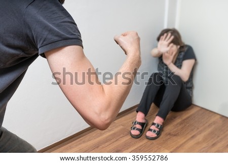 Domestic violence concept. Jealous husband is abusing his wife and want hit her with fist.