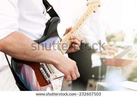 man playing guitar, close-up. Guitarist playing an electric guitar.