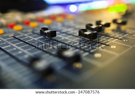 Part of an audio sound mixer with buttons and sliders. with shallow depth of field