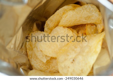Opened pack of delicious spicy potato chips view inside of pack macro with shallow depth of field