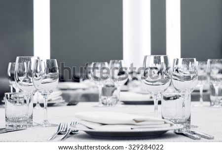 Glasses and plates on table in restaurant food background,Table set for an event party or wedding reception