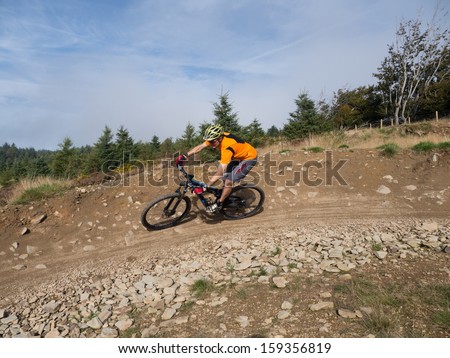 Mountain Biker Riding A Trail In A Mountain Bike Park In South Wales, Uk On A Sunny Day In The Fall