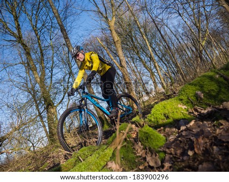 ALMERE, NETHERLANDS - FEB. 3, 2014: Mountain biker test riding a brand new  state of the art mountainbike in a Dutch forest to assess whether it provides a smooth and easy ride on rough terrain