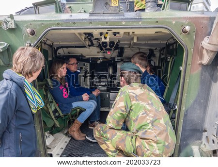 ALMERE, NETHERLANDS - 12 APRIL 2014: People sitting in the rear of a military vehicle on display during the first National Security Day held in the city of Almere