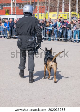 ALMERE, NETHERLANDS - 12 APRIL 2014: Member of a SWAT team and his dog during a demonstration on the first National Security Day held in the city of Almere