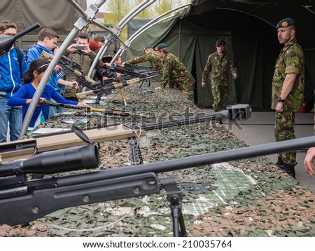 ALMERE, NETHERLANDS - 23 APRIL 2014: On National Army Day kids of all ages  are allowed to hold machine guns of all sorts under guidance of the military in Almere