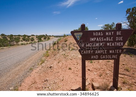 Sign warning people of road danger in bad weather and to be prepared, Hole in the Rock road, Utah desert.