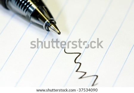 macro shot of ballpoint ink pen on ruled paper.