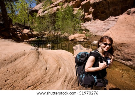 Smiling, young woman with backpack enjoying the southern Utah outdoors. Outdoor adventure/ Active lifestyle concept.